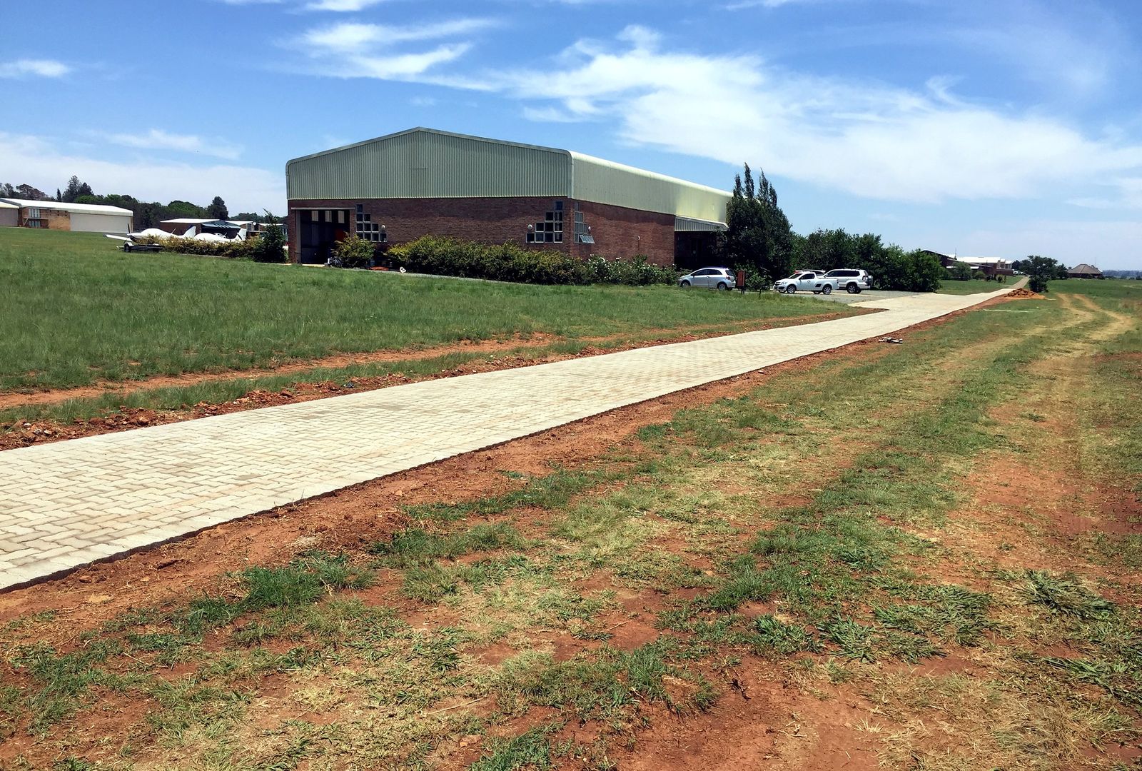 Institutional access path leading to an airfield hangar