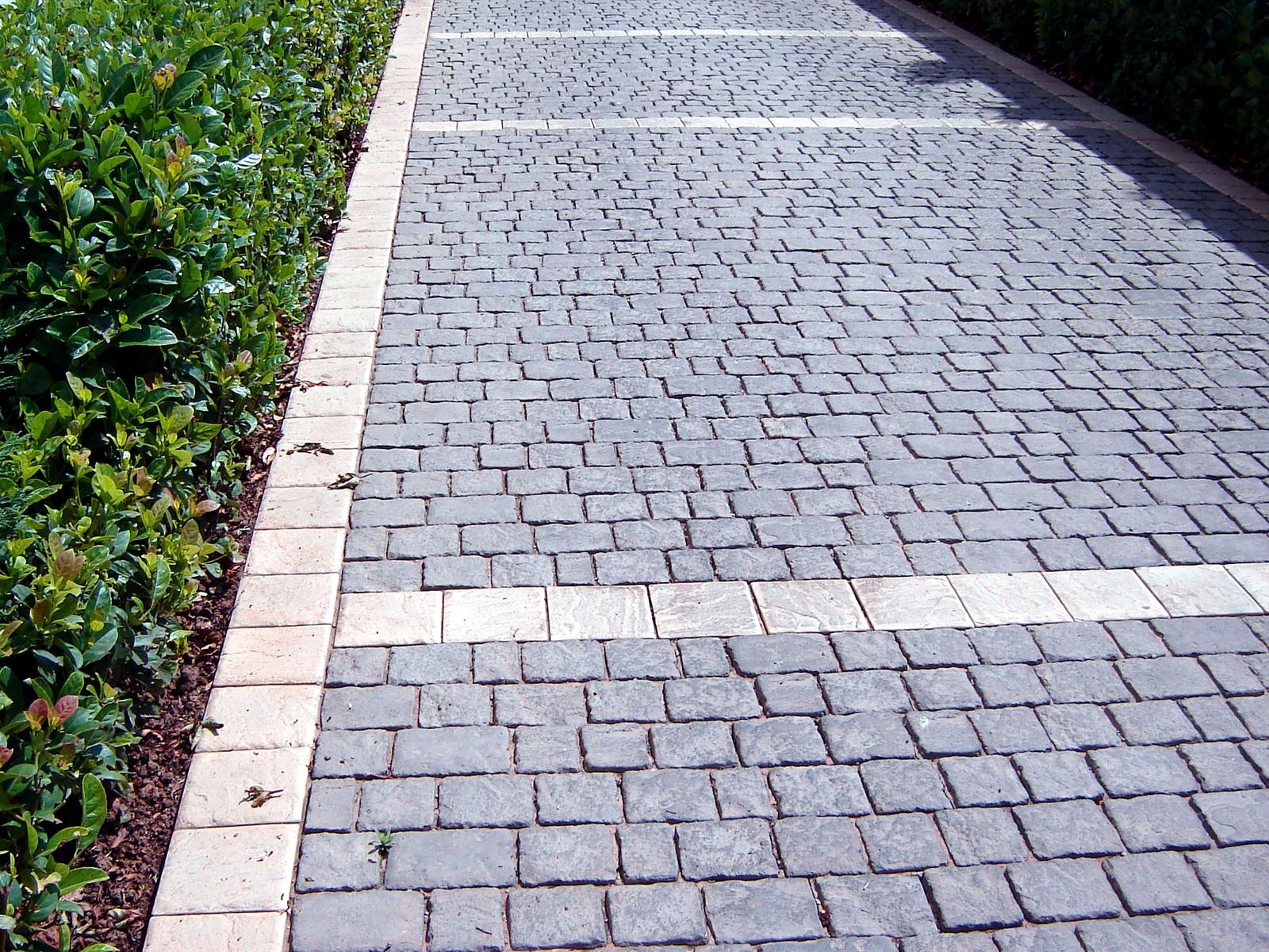 Premium cobble finish — grey cobble driveway bordered by hedging